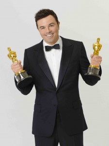 Seth MacFarlane holding oscar statues